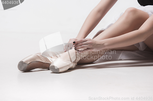 Image of Ballerina dancer sitting down with her legs crossed