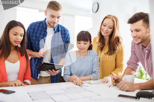 Image of creative team with blueprint working at office