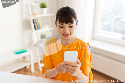 Image of happy asian woman with smartphone at home