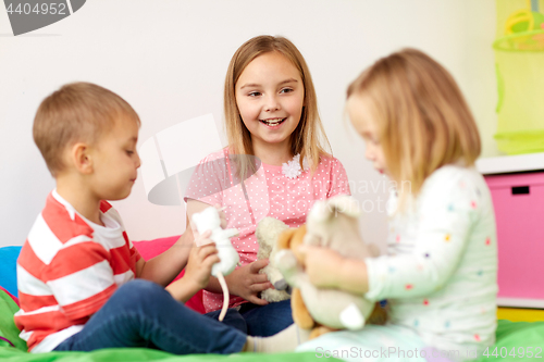 Image of happy kids playing with plush toys at home