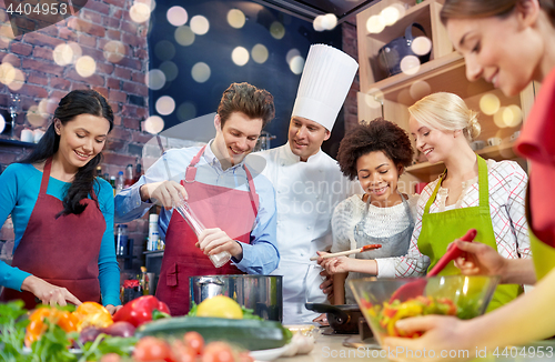 Image of happy friends and chef cook cooking in kitchen