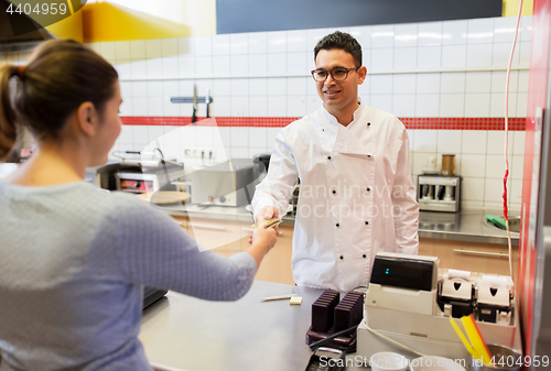 Image of seller and customer paying at fast food restaurant