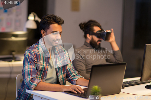 Image of creative man with laptop working at office