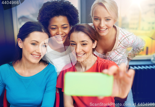 Image of happy young women taking selfie with smartphone