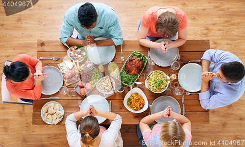 Image of group of people at table praying before meal