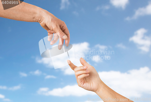 Image of close up of senior and young woman hands over sky