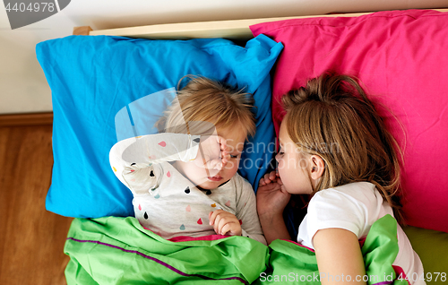 Image of happy little girls sleeping in bed at home