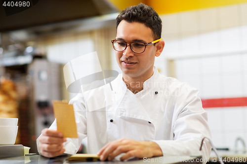 Image of chef at kebab shop with order or paper note