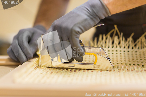 Image of assembler with staple gun making furniture