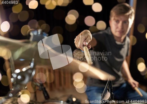 Image of male musician playing drum kit at concert