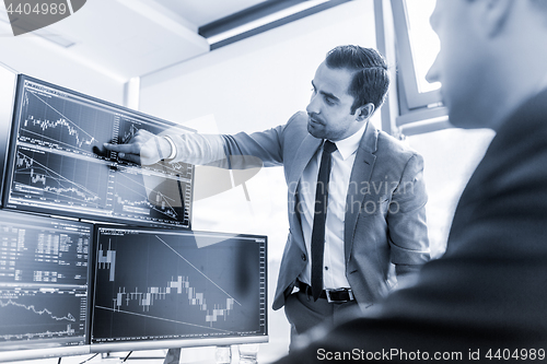 Image of Stock brokers trading online in corporate office.