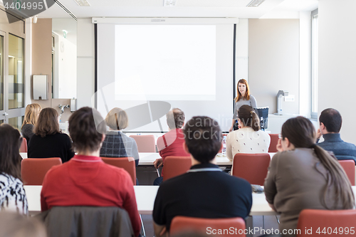 Image of Woman giving presentation in lecture hall at university.