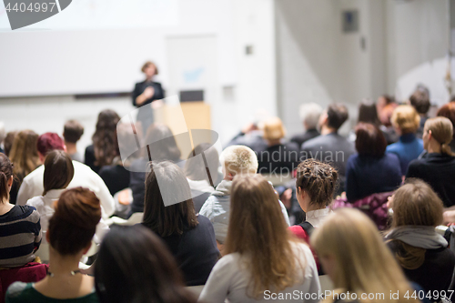 Image of Woman giving presentation in lecture hall at university.