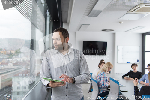 Image of Businessman Using Tablet In Office Building by window