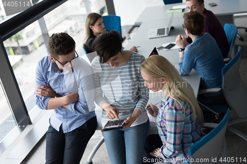 Image of group of Business People Working With Tablet in startup office