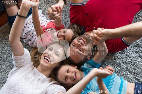 Image of happy family lying on the floor