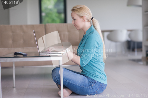 Image of young women using laptop computer on the floor