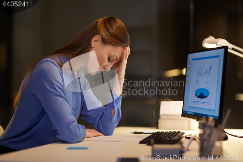 Image of businesswoman with computer at night office