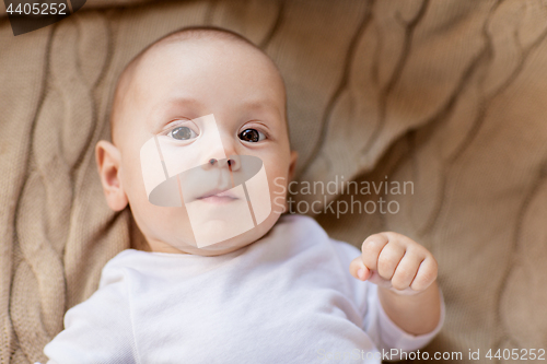 Image of sweet little baby boy lying on knitted blanket