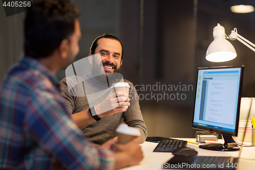 Image of creative team drinking coffee at night office