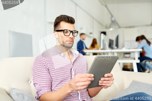 Image of man in glasses with tablet pc working at office