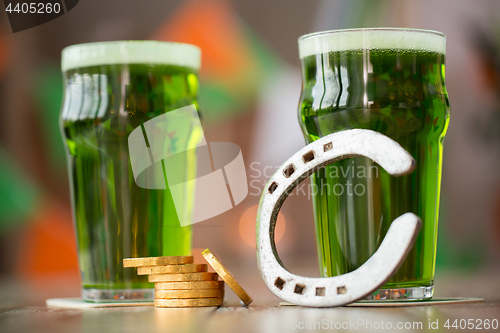 Image of glass of green beer, horseshoe and gold coins