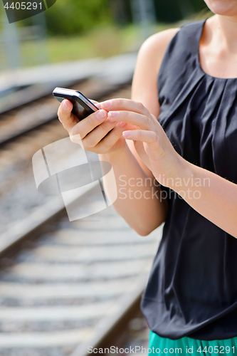 Image of Closeup of woman hands using phone