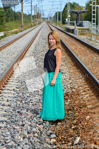 Image of Standing girl between two railway path