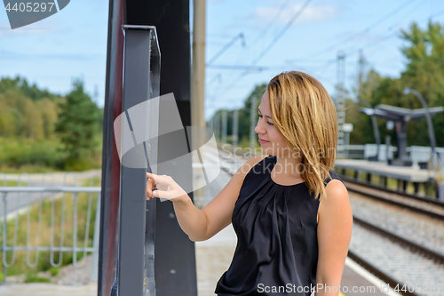 Image of Woman looking a timetable in a station