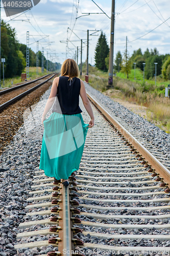 Image of Young women walking on the rail track