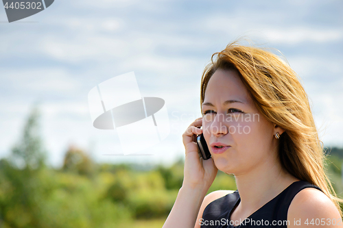 Image of Beautiful caucasian girl talking to smart phone