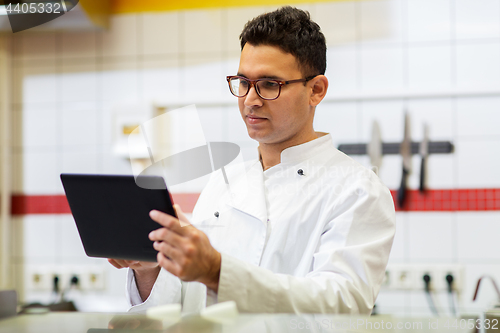 Image of chef cook with tablet pc at restaurant kitchen