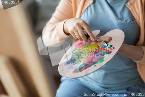 Image of artist with palette knife painting at art studio