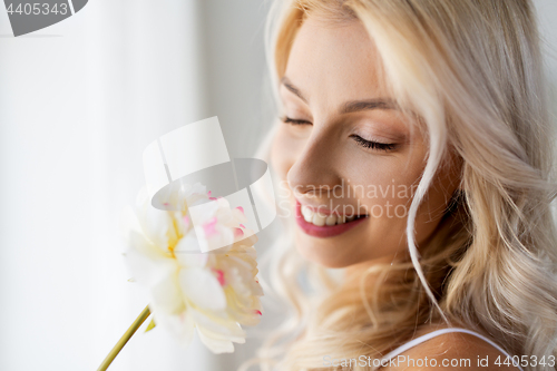 Image of close up of beautiful young woman smelling flower