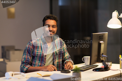 Image of creative man with tablet pc at night office