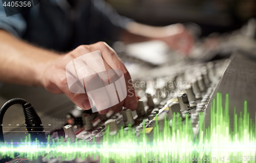 Image of hands on mixing console in music recording studio