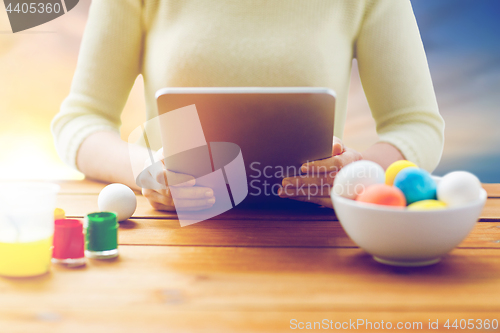 Image of close up of woman with tablet pc and easter eggs