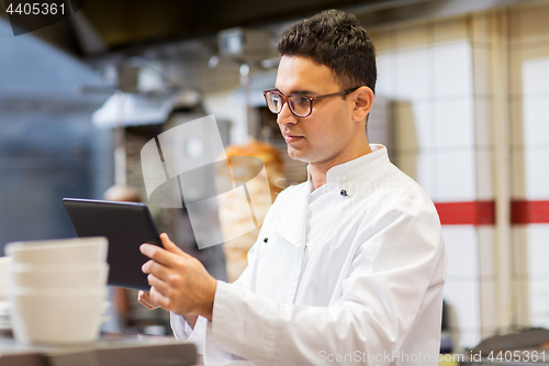 Image of chef cook with tablet pc at restaurant kitchen