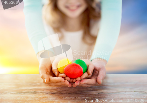 Image of close up of girl and mother holding easter eggs