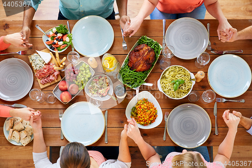 Image of group of people at table praying before meal