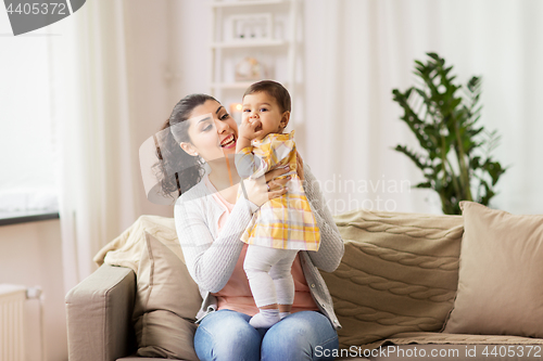 Image of happy smiling mother with baby daughter at home