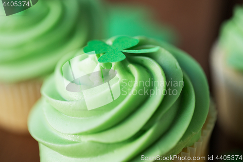 Image of close up of green cupcake with shamrock decoration