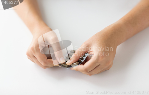 Image of woman hands opening pack of medicine pills