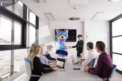 Image of boss dresed as bear having fun with business people in trendy of