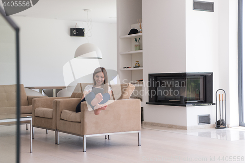 Image of woman sitting on sofa with tablet computer