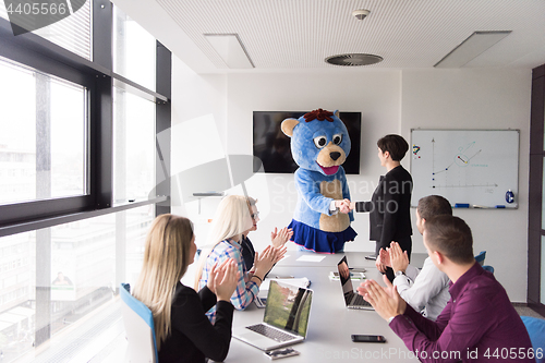 Image of boss dresed as bear having fun with business people in trendy of