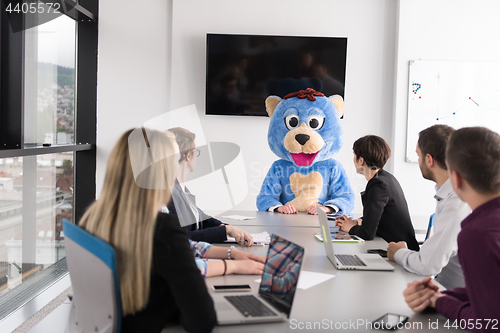 Image of boss dresed as bear having fun with business people in trendy of