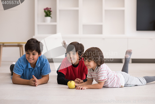 Image of boys having fun with an apple on the floor