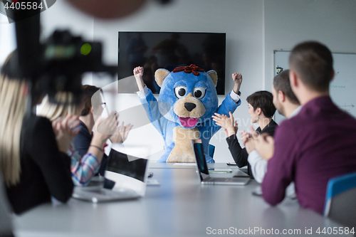 Image of boss dresed as bear having fun with business people in trendy of