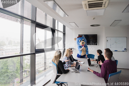 Image of boss dresed as bear having fun with business people in trendy of